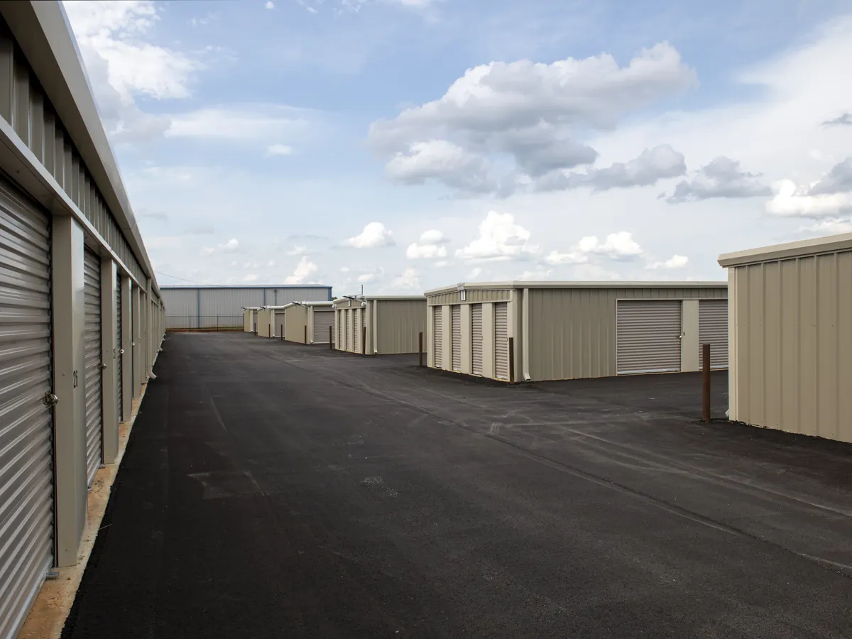 A paved drive between storage buildings